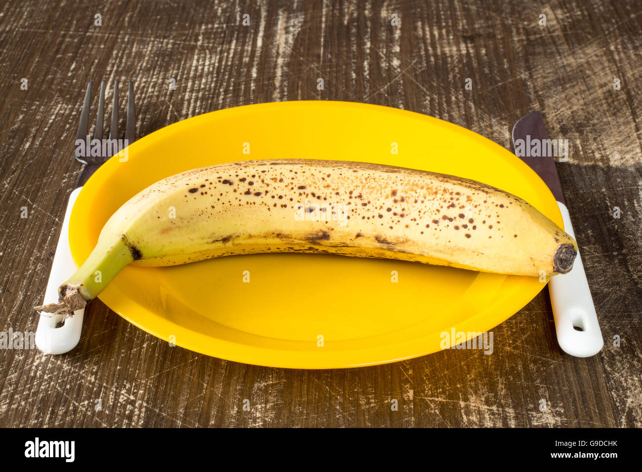 Fork,knife and plate with banana on wooden background Stock Photo Alamy
