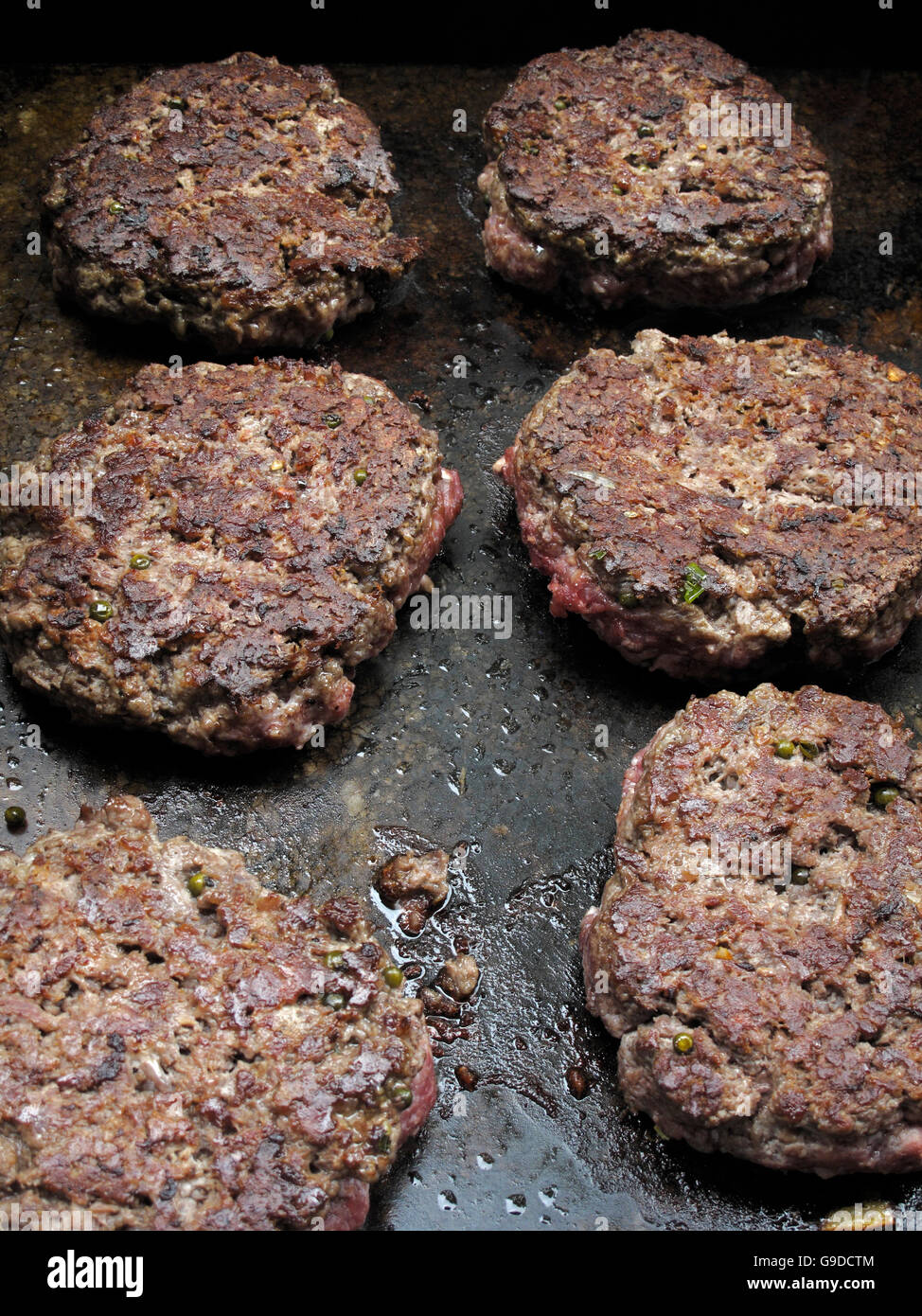 Hamburger patties cooking on a grill Stock Photo Alamy