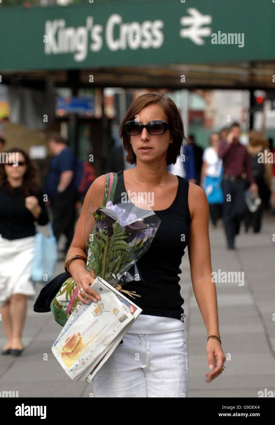 A commuter arrives with flowers at Kings Cross Station, London, on the first anniversary of the terrorist bombings. Stock Photo