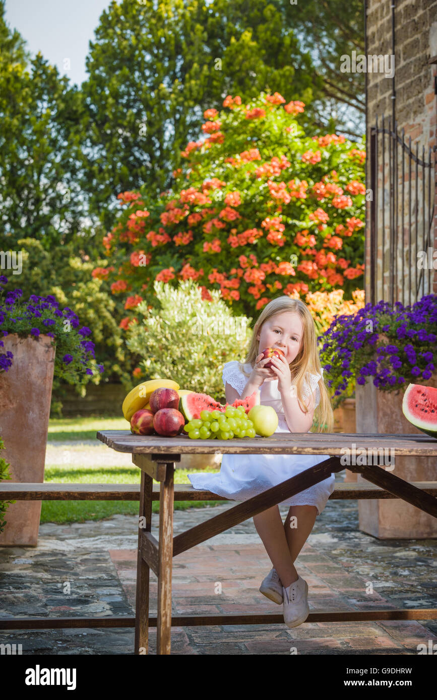 Fruity smile girl eating a vitamin in the form of nectarines. Stock Photo