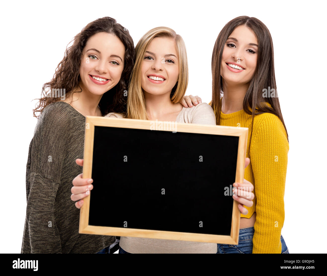 Studio portrait of three teenage girls holding a chalkboard Stock Photo