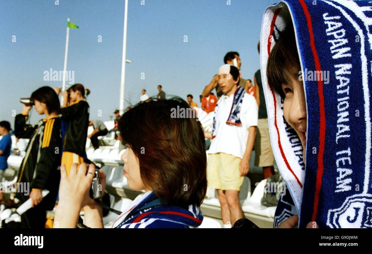 Soccer - Asian Cup 2000 - Group C - Japan v Uzbekistan. A Japan fan protects her head from the sun with her scarf as she watches her team defeat Uzbekistan 8-1 Stock Photo