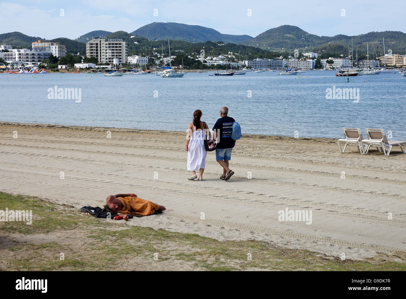 Couple walking on San Antonio beach in  Ibiza Spain Stock Photo