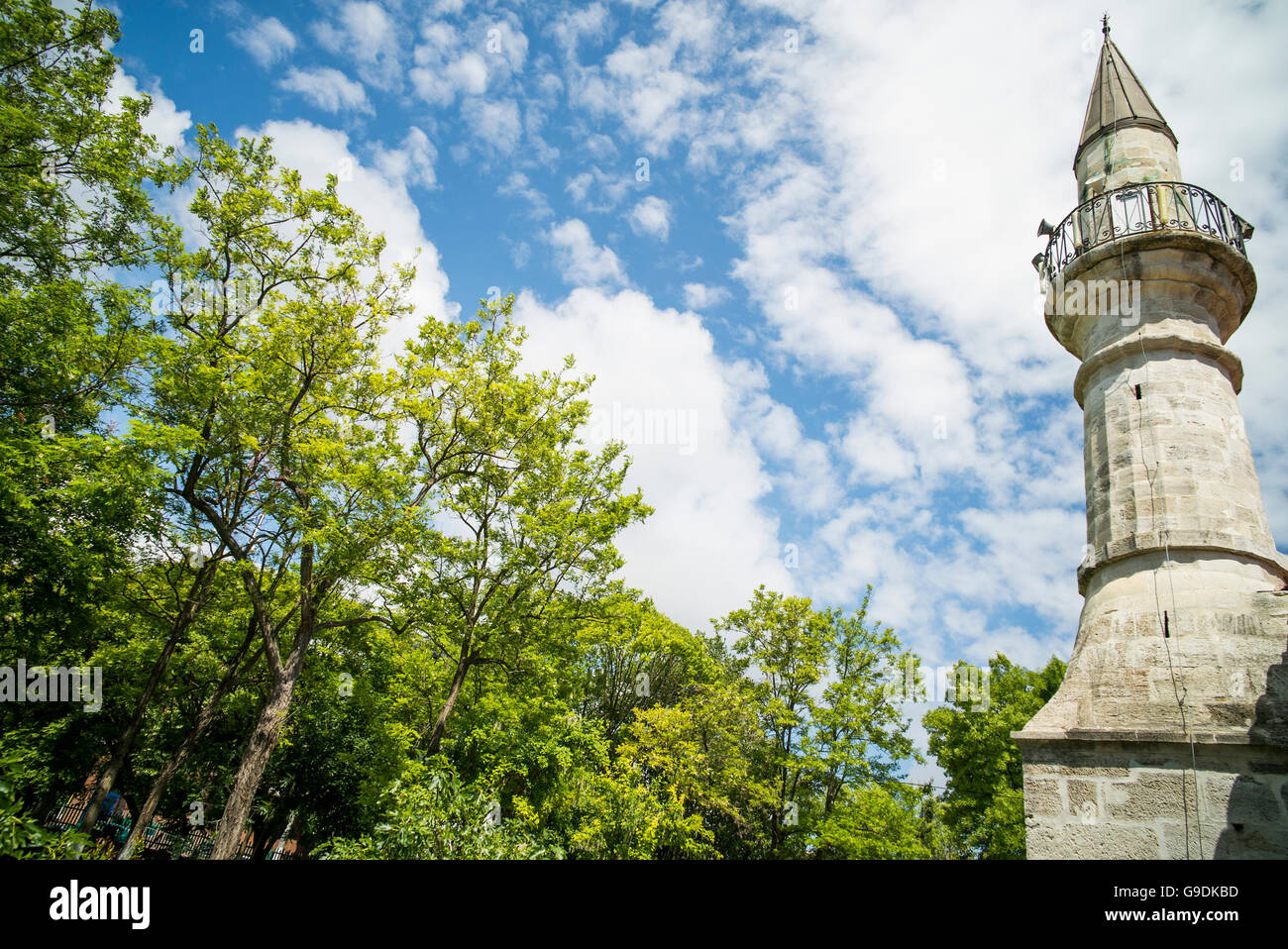 Color image of a minaret from a mosque, against a blue sky. Stock Photo