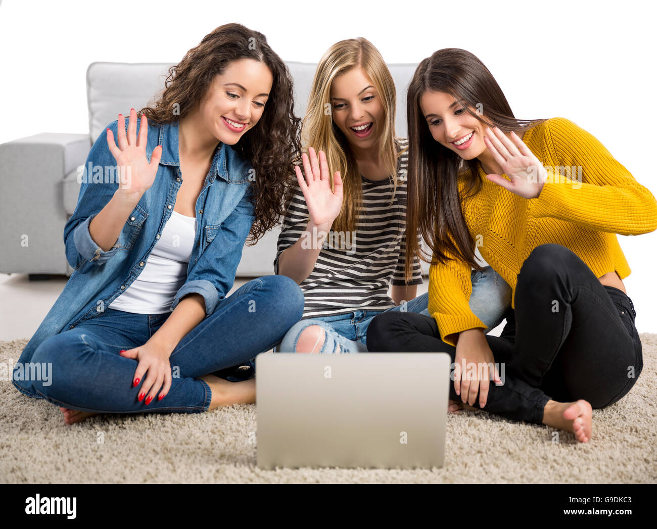 Happy teen girls studying at home with a laptop Stock Photo