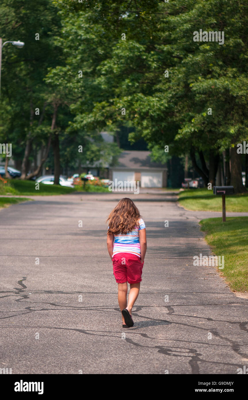 An 8-10 year old caucasian girl walks away. Stock Photo