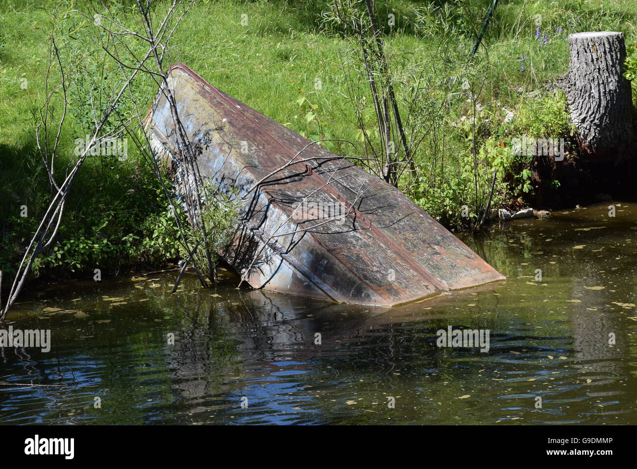 Half-Sunk Boat in a Pond Stock Photo