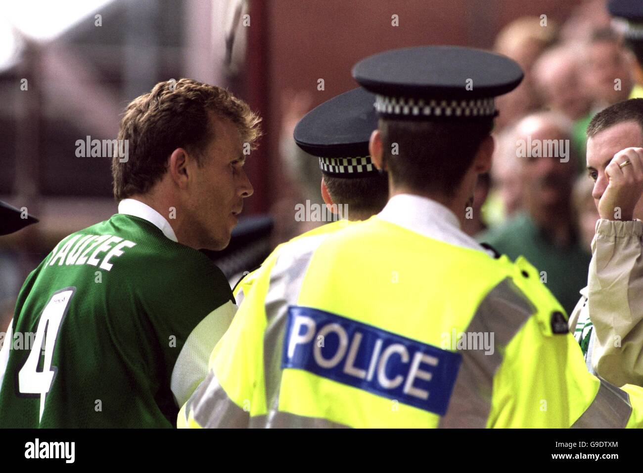 Hibernian's Franck Sauzee (l) and police confront the Hibernian fan (r) who threw the tea and pie at Heart of Midlothian goalkeeper Antti Niemi Stock Photo