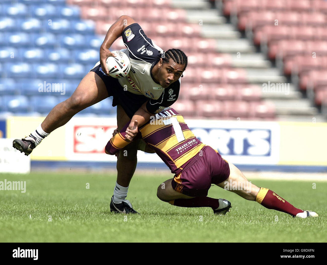 Leeds' Ali Lauitiiti (left) is tackled by Huddersfield's Robbie Paul during the Engage Super League match at Galpharm Stadium, Huddersfield. Stock Photo