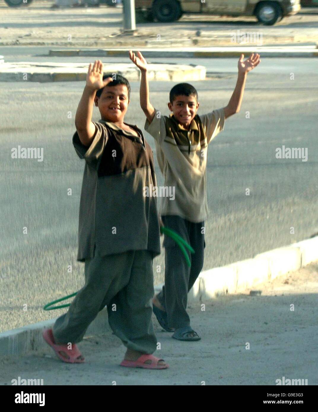 Iraqi children wave as normal life returned to some areas of Iraq and in the city of As Samawah the capital of the Al Muthanna province, where the local sheep market is again thriving. Stock Photo