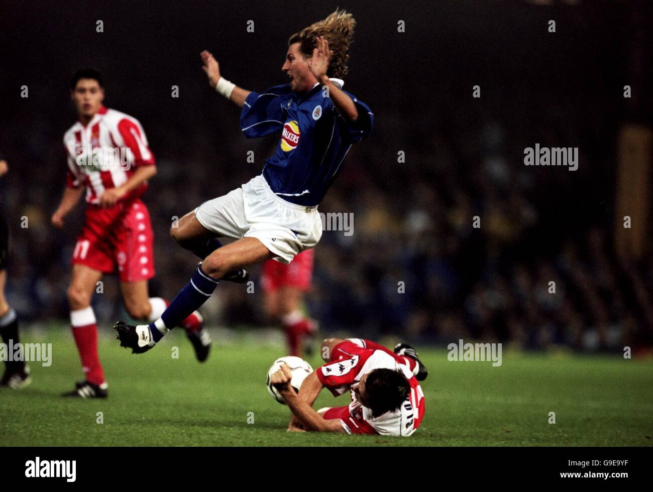 Soccer - UEFA Cup - First Round First Leg - Leicester City v Red Star Belgrade. Leicester City's Robbie Savage (c) is sent flying by Red Star Belgrade's Stevo Glogovac (r) Stock Photo