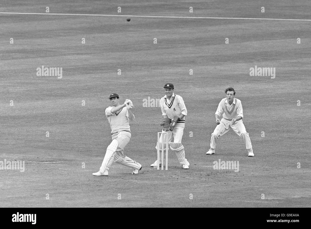 Players' Fred Trueman (l) clouts the ball to the boundary, watched by Gentlemen's Alan Smith (c) and Edward Craig (r) Stock Photo