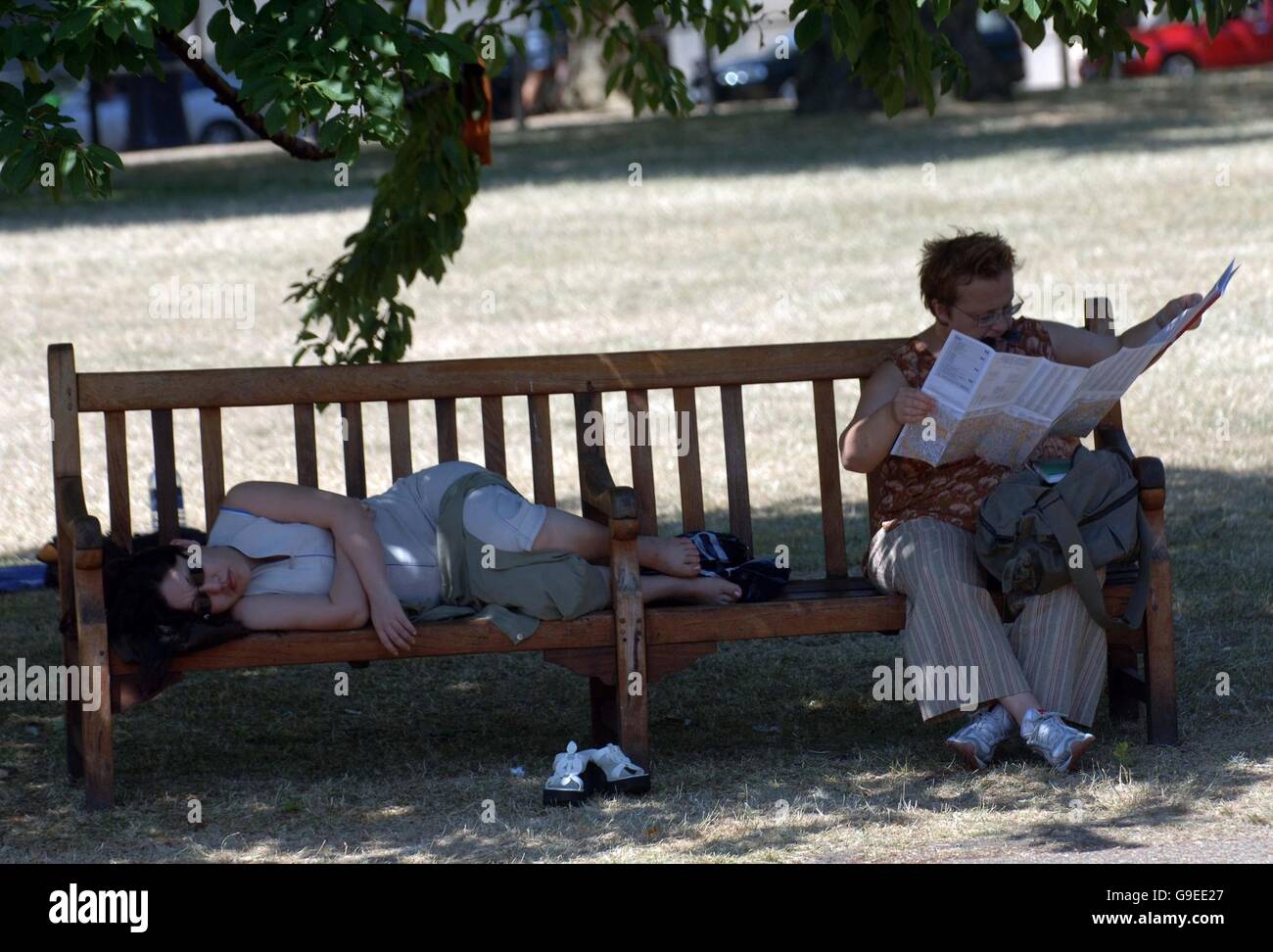 People in shade at London's St James' park during the current hot spell when temperatures are expected to peak tomorrow (Wed). Stock Photo