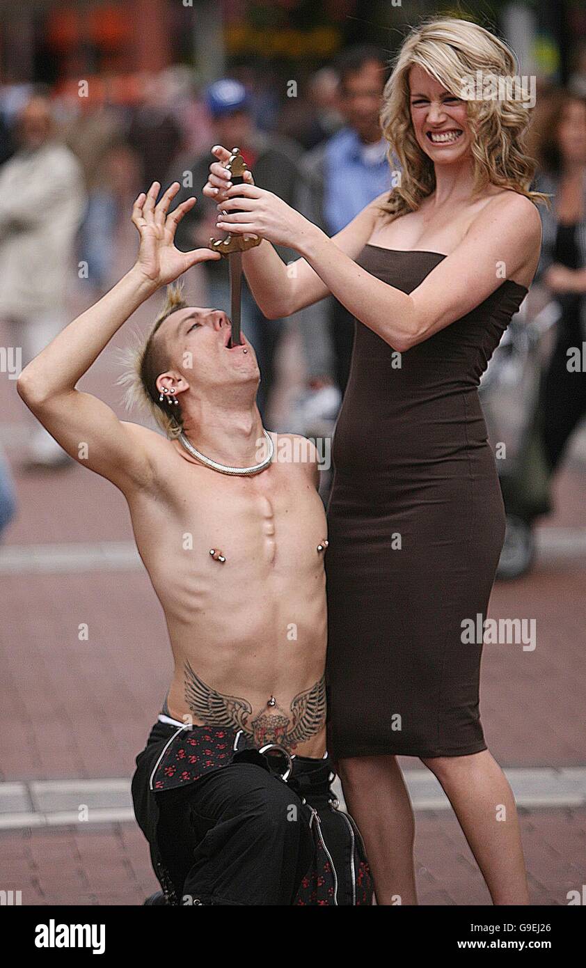 Top Irish model Jenny Lee removes a sword from the mouth of an artist known as the Australian Space Cowboy, in Dublin city centre, to launch the first ever Street Performance World Championship, to be held on August 5th and 6th at Merrion Square in the city. Stock Photo
