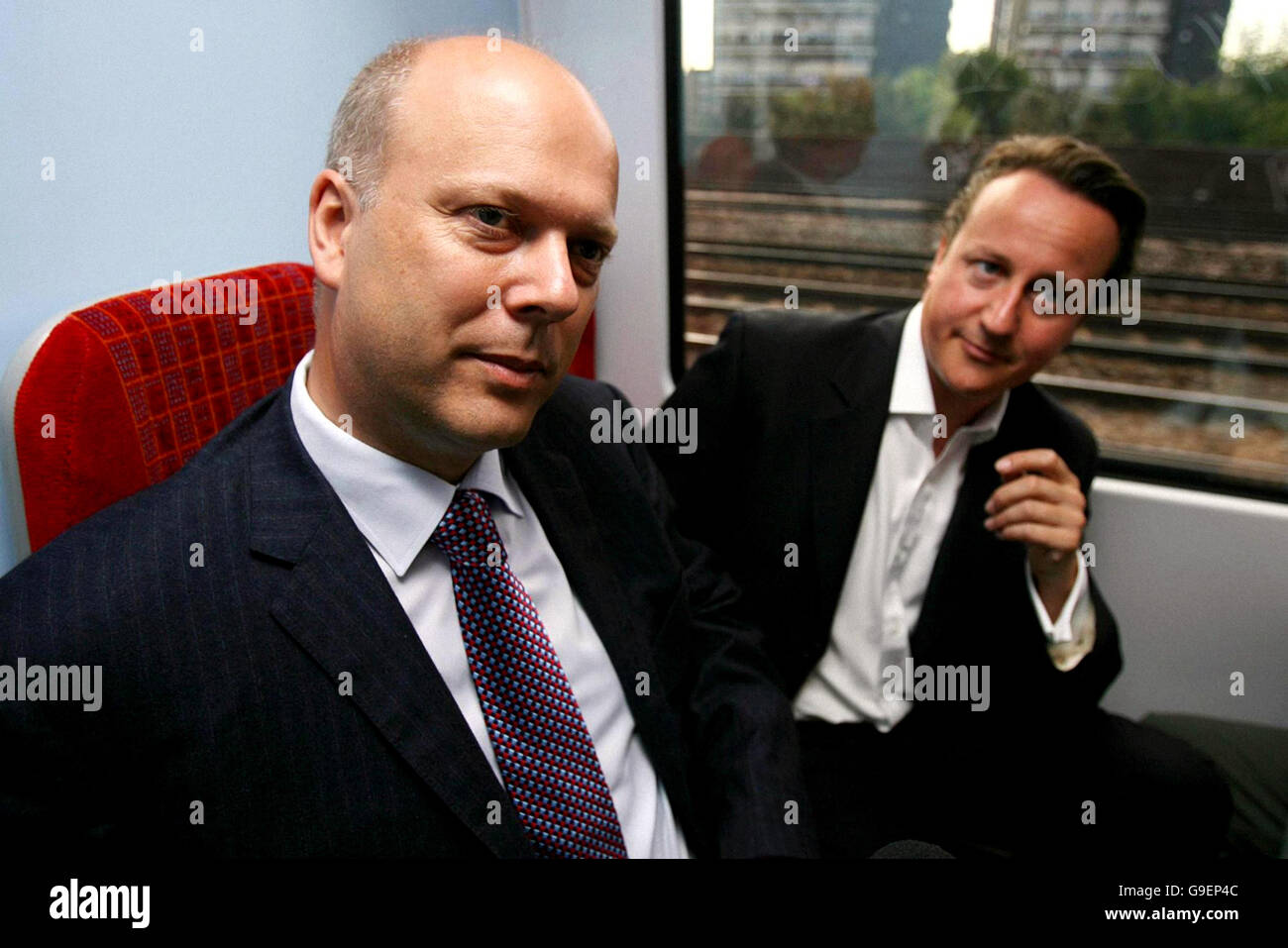 Shadow Transport Secretary Chris Grayling (left) and Conservative party leader David Cameron speak with commuters on a train to Waterloo station, London, after Mr Cameron's party said that the break-up of the railways by the last Tory government has pushed up running costs and hindered expansion. Stock Photo