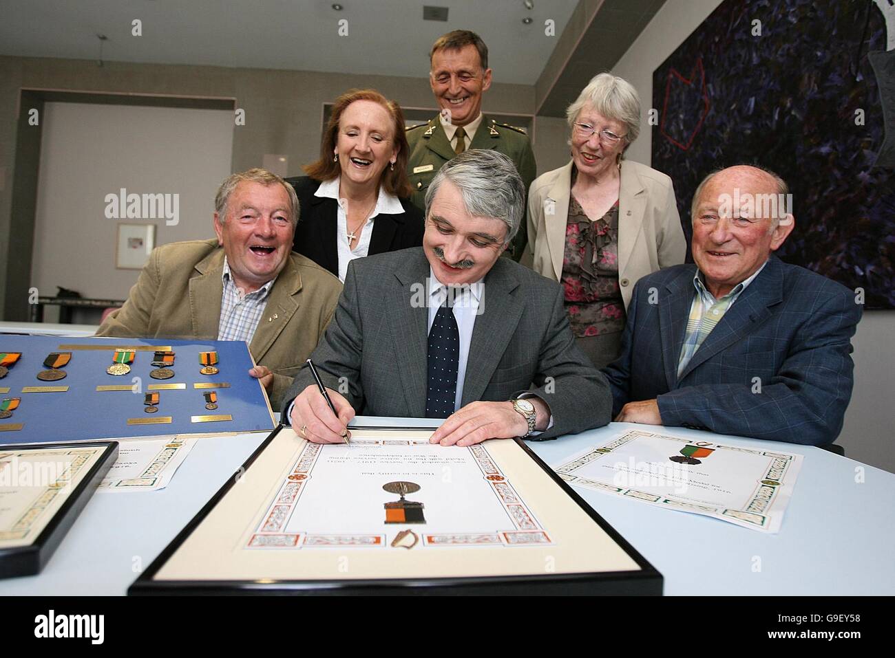 Minister for Defence Willie O'Dea (centre) signs official certificates to replace lost,s tolen or destroyed 1916/War of Independence Medals, alongside relatives of 1916 survivors (left to right) Dominick Darling, Gabrielle Darling Byrne, Colonel Chris Moore, Eilish O'Toole and Con Clarke, at Government Buildings in Dublin. Stock Photo