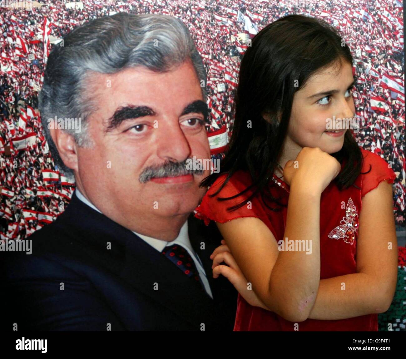 Sophie Jones, 8, from Lebanon, stands in front of a portrait of assassinated Lebanese Prime Minister Rafik Hariri during the opening of a photographic exhibition, entitled 'Beirut - Before and After' at Dublin Castle, Dublin. Stock Photo