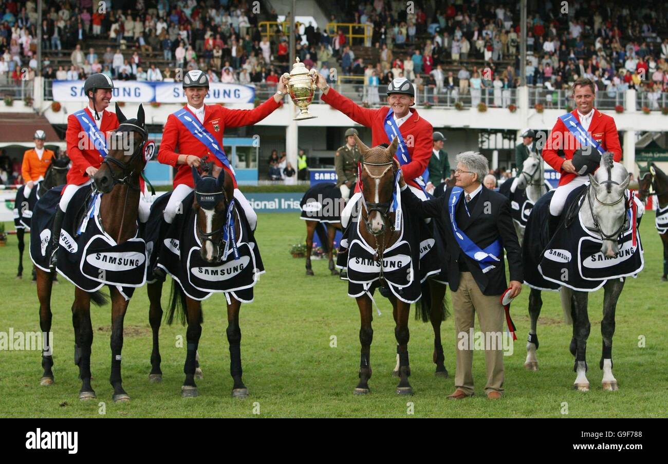 Germany's (left to right) Rene Tibbel, Ulrich Kirchhoff, Thomas Voss and Heinrich Engemann hold aloft the Aga Khan challenge trophy after their team won at the Dublin Horse Show at the RDS, Dublin. Stock Photo