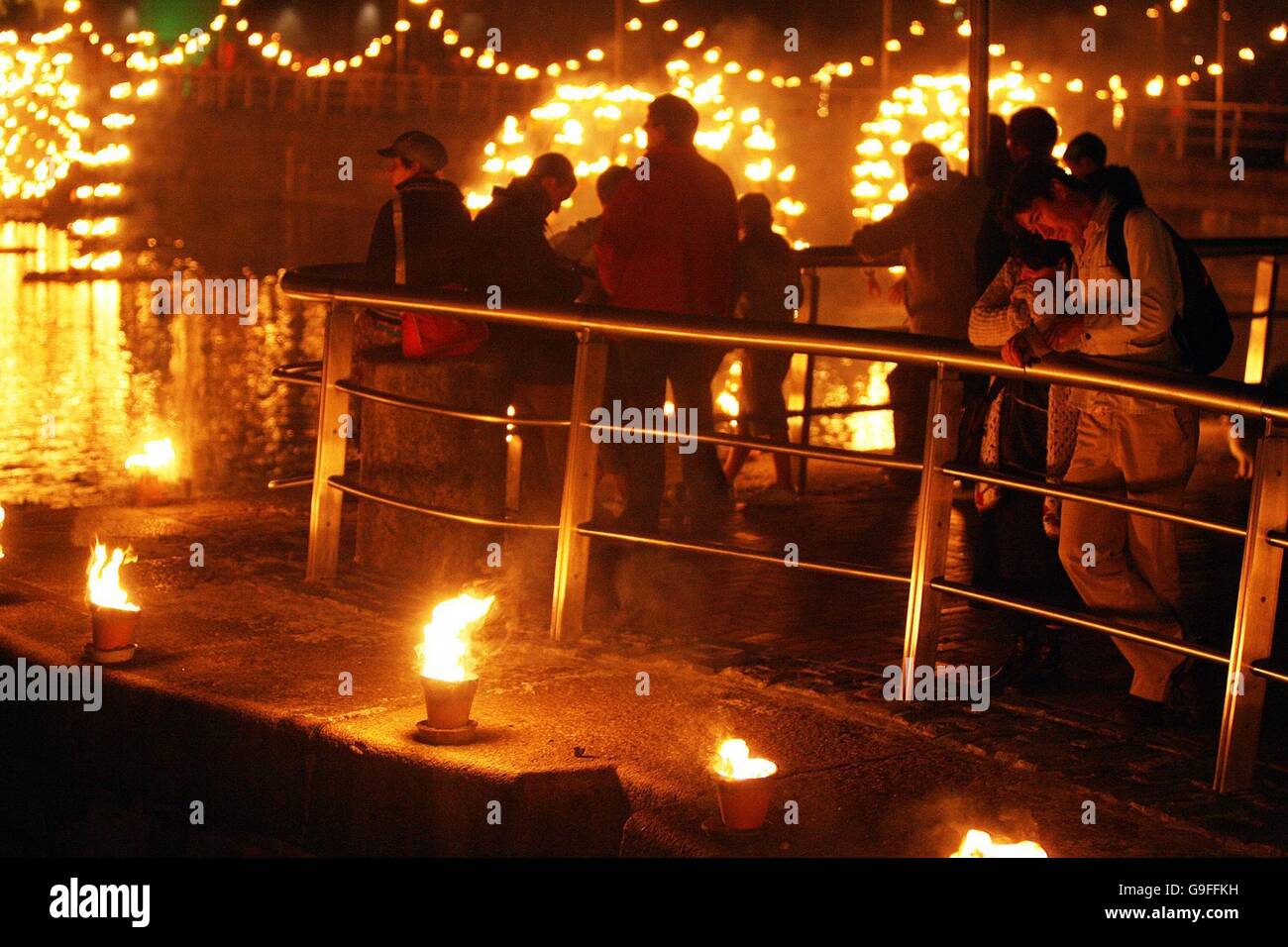 People watch a fire installation by French group Compagnie Carabosse at George's Dock in Dublin. Stock Photo