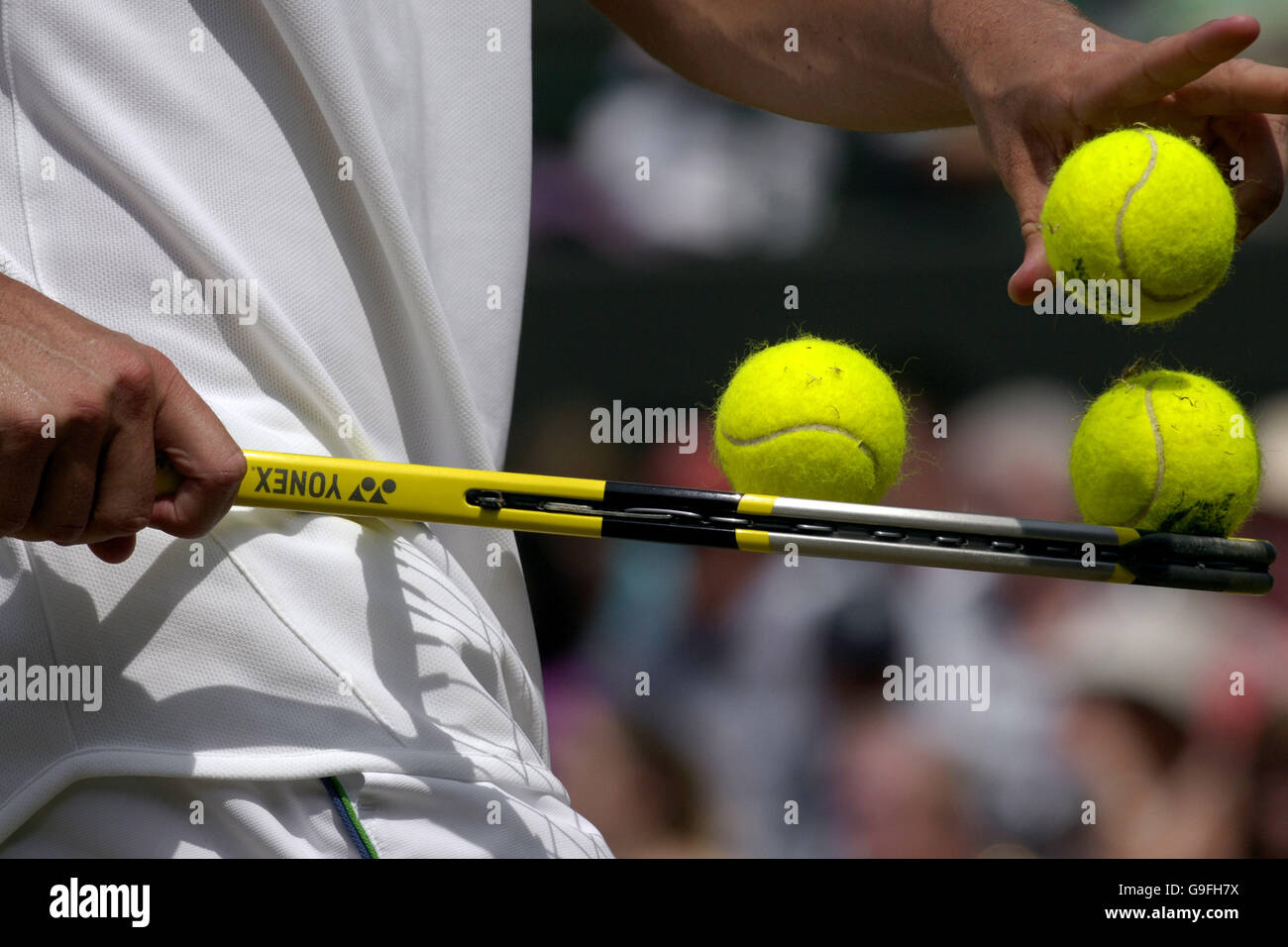 A player balances three balls on a racket during the forth round at Wimbledon. Stock Photo