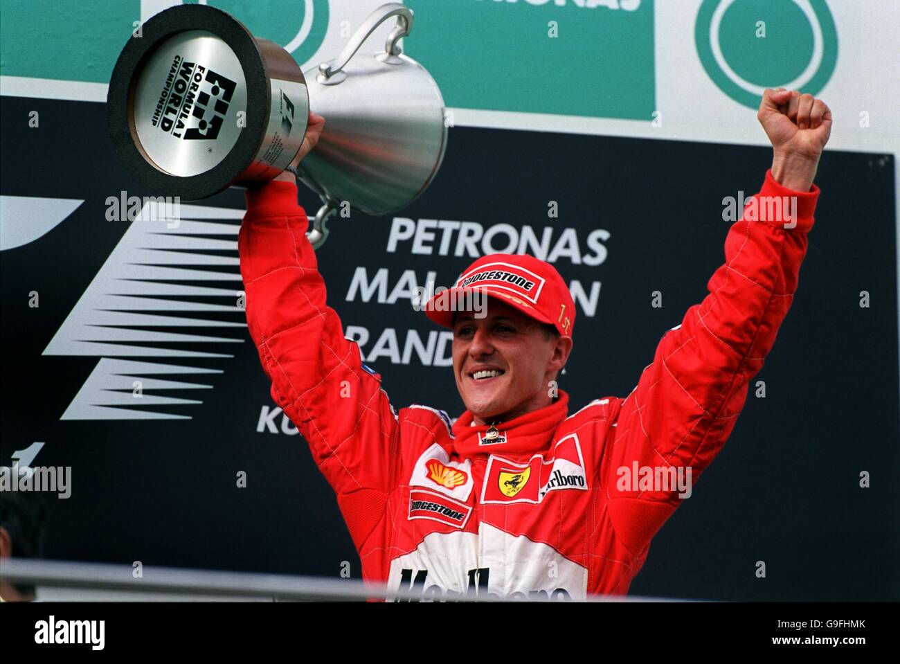 Michael Schumacher triumphantly lifts the World Championship trophy