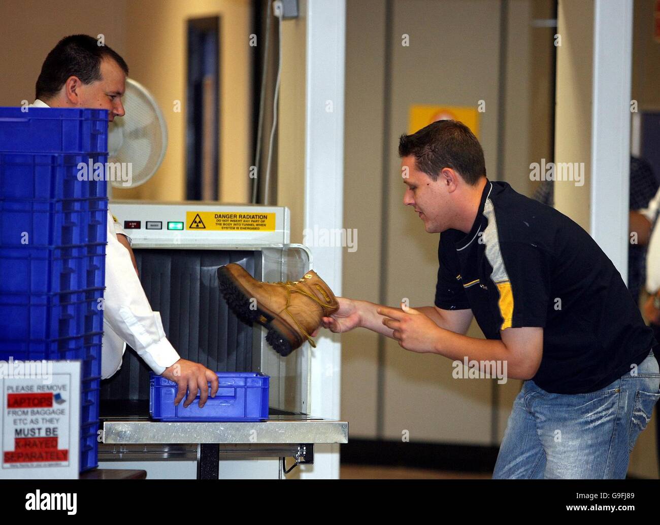 Passengers at Belfast International Airport remove their shoes at a