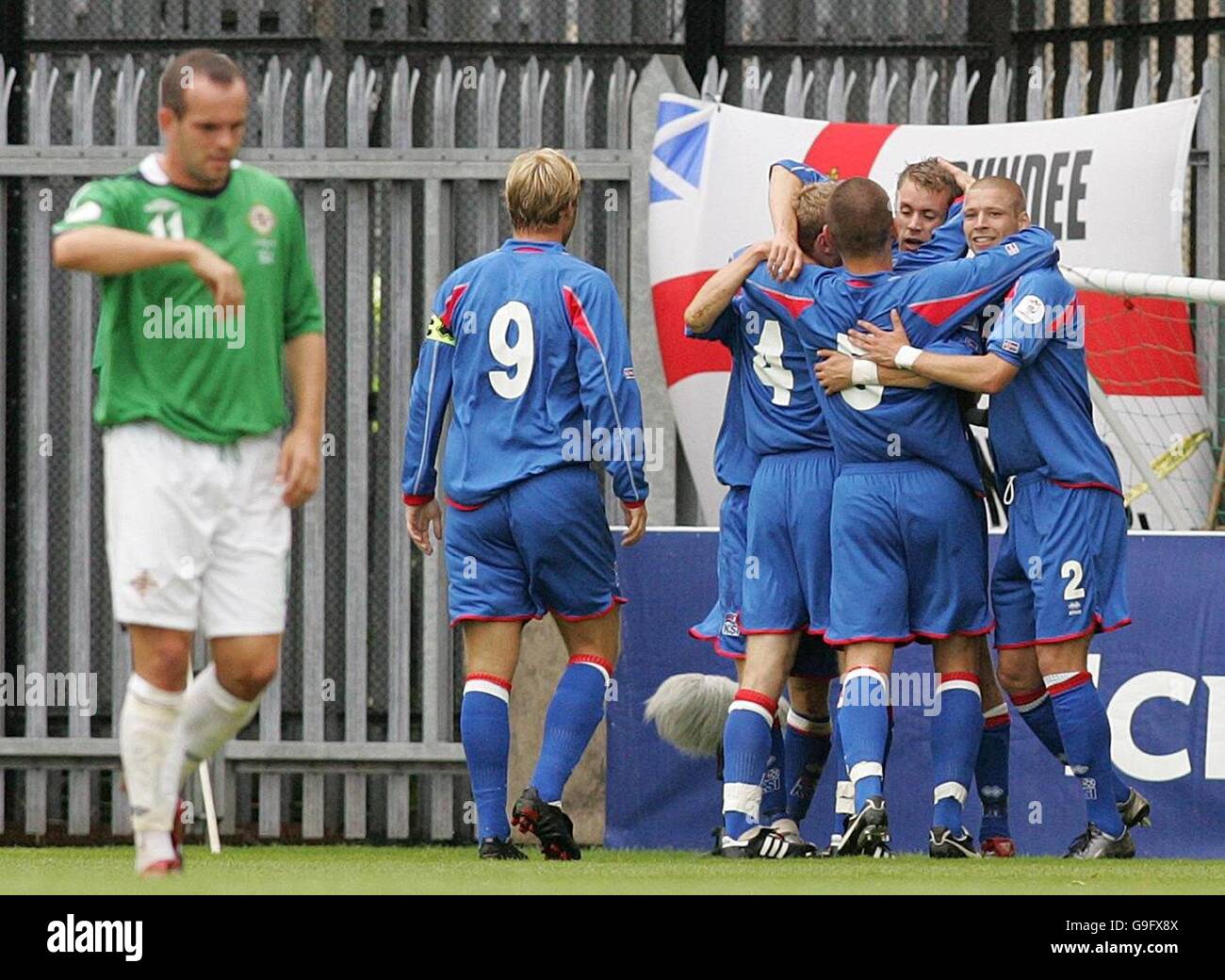 Northern Ireland's Stuart Elliot, (left), walks away while Iceland players celebrate in the background after scoring their first goal against Northern Ireland during the European Championship qualifying match at Windsor Park, Belfast. Stock Photo