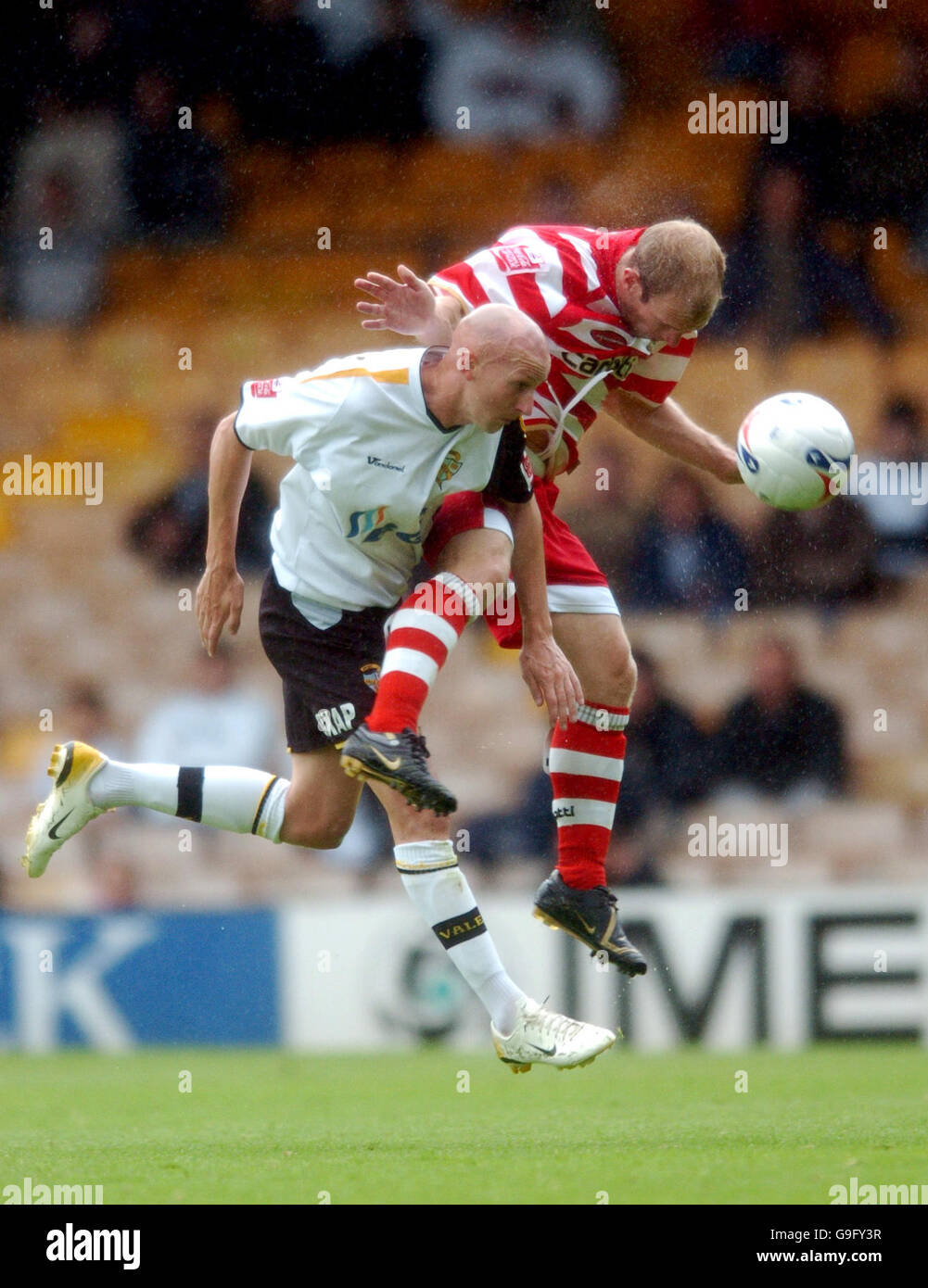 Port Vale's Danny Whitaker and Doncaster Rovers' Gareth Roberts battle for possession of the ball Stock Photo