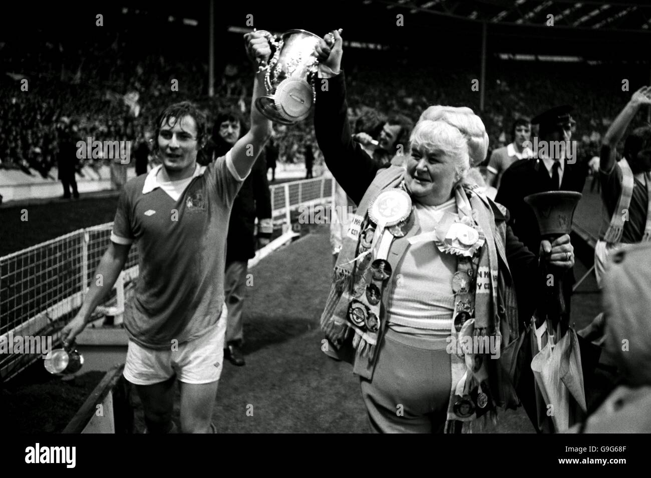 Soccer - League Cup Final - Manchester City v Newcastle United. Manchester City's Asa Hartford (l) and famous fan Helen 'The Bell' Turner parade the League Cup around Wembley after their 2-1 victory Stock Photo