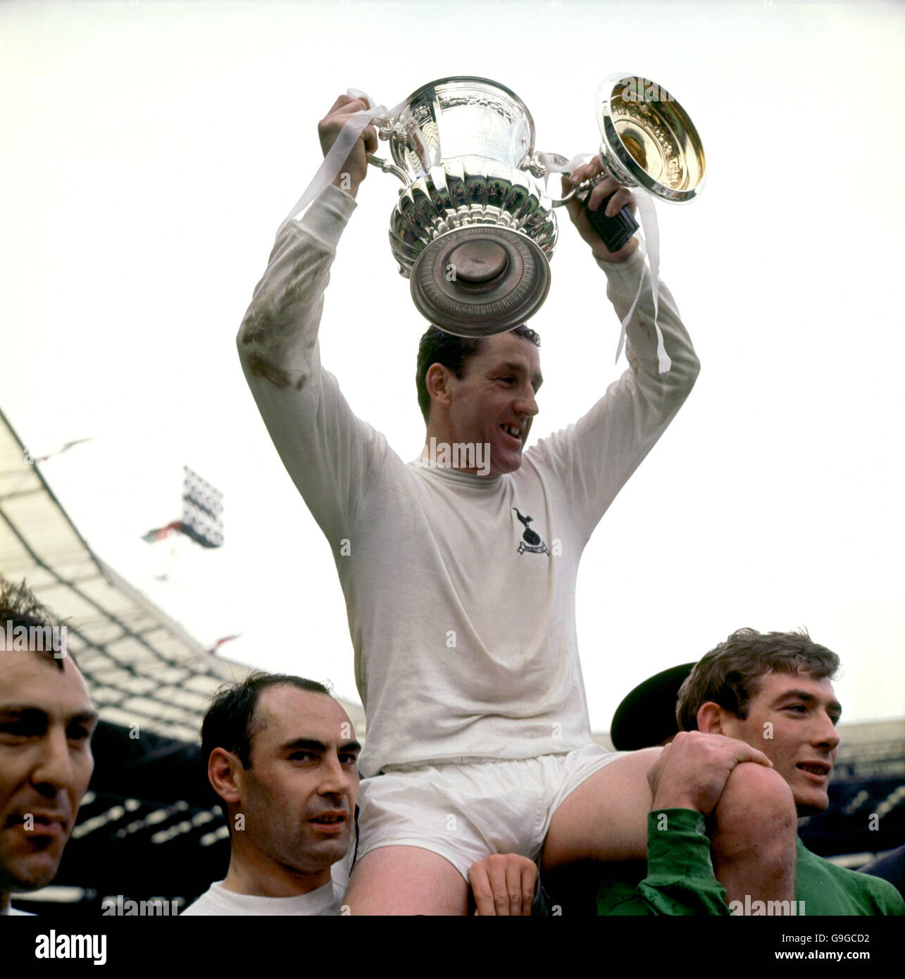 Tottenham Hotspur captain Dave Mackay celebrates with the FA Cup on the shoulders of Alan Gilzean (l) and Pat Jennings (r) Stock Photo