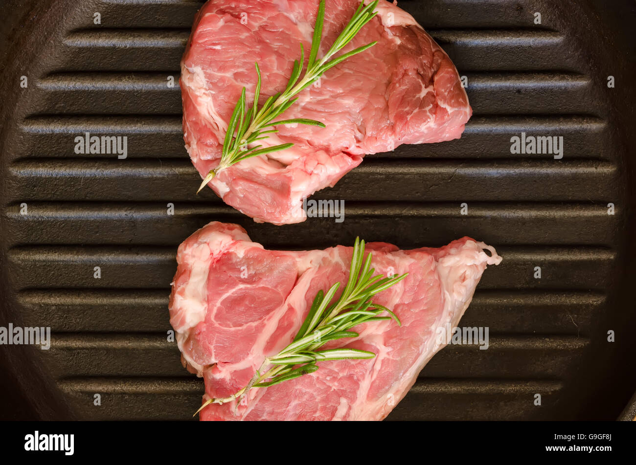 Raw steak with rosemary on castiron frying pan Stock Photo Alamy