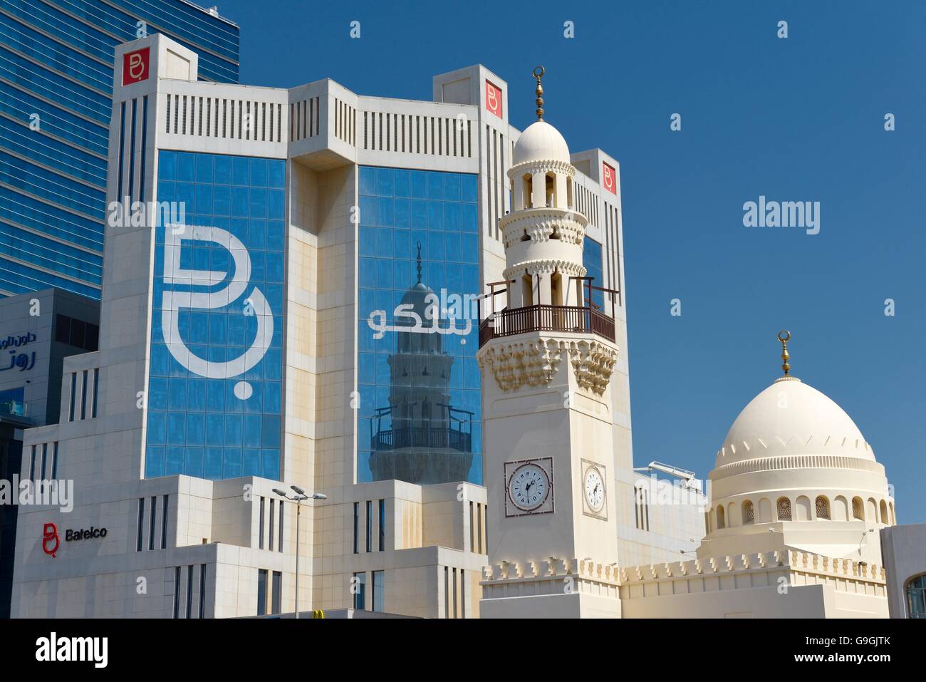 The unique clock tower minaret in the new Al Yateem Mosque in Manama, Bahrain stands before the Batelco telecoms offices Stock Photo