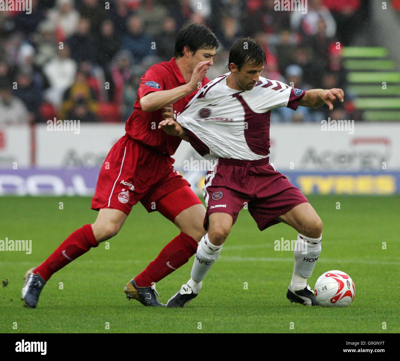 Hearts' Neil McCann (right) holds of Aberdeen's Michael Hart from the ball during the Bank of Scotland Premier League match at Pittodrie Stadium, Aberdeen. Stock Photo