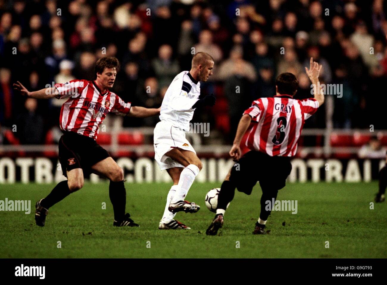 Manchester United's David Beckham (c) keeps the ball away from Sunderland's Stefan Schwarz (l) and Michael Gray (r) Stock Photo