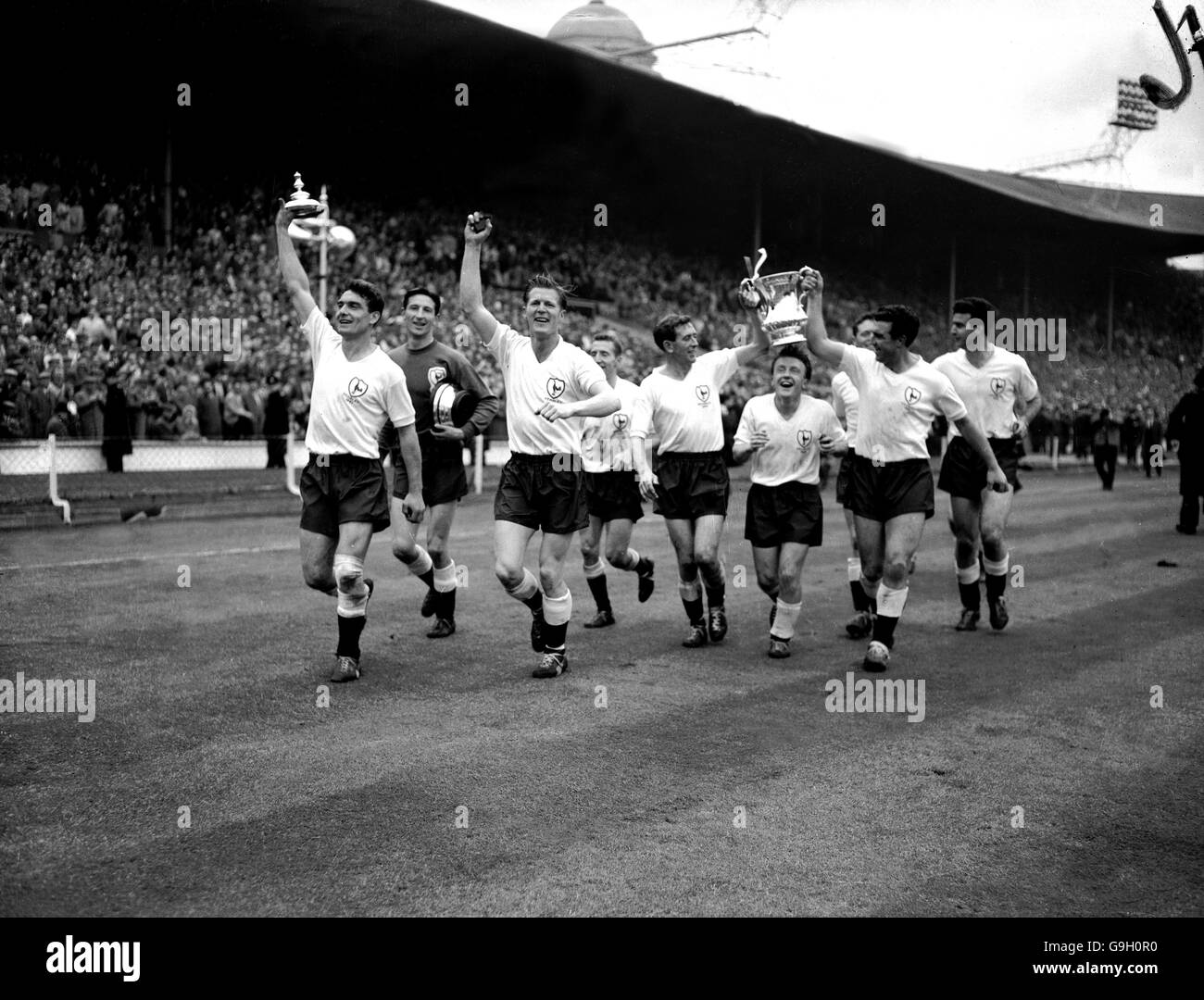 Tottenham Hotspur celebrate with the FA Cup after their 2-0 win secured The Double: (l-r) Ron Henry, Bill Brown, Peter Baker, Cliff Jones, Danny Blanchflower, Terry Dyson, Les Allen, Bobby Smith, Maurice Norman Stock Photo