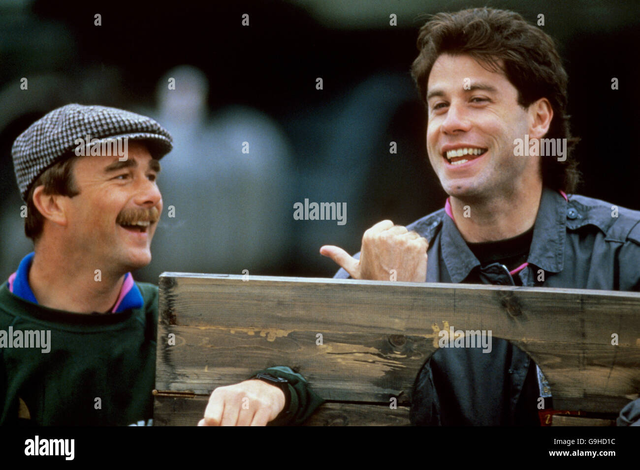 (L-R) Nigel Mansell and John Travolta pose in the stocks to publicize the Grand Knockout Tournament Stock Photo