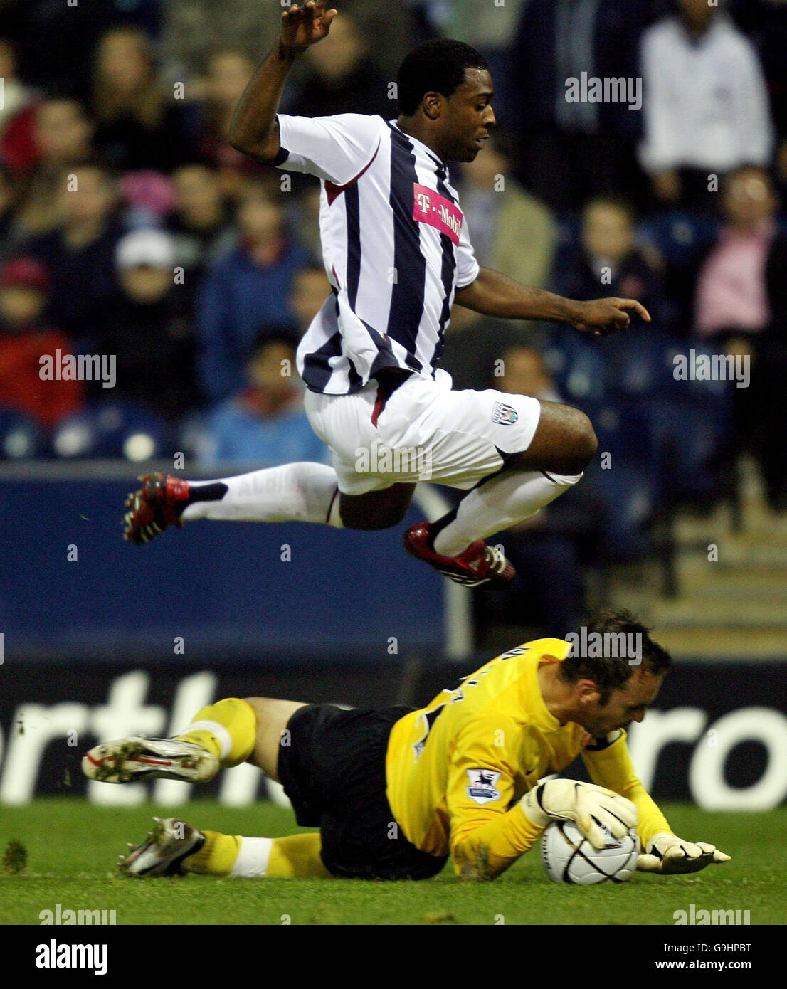 Arsenal goalkeeper Manuel Almunia saves at the feet of West Bromwich Albion's Nathan Ellington during the Carling Cup third round at The Hawthorns, West Bromwich. Stock Photo