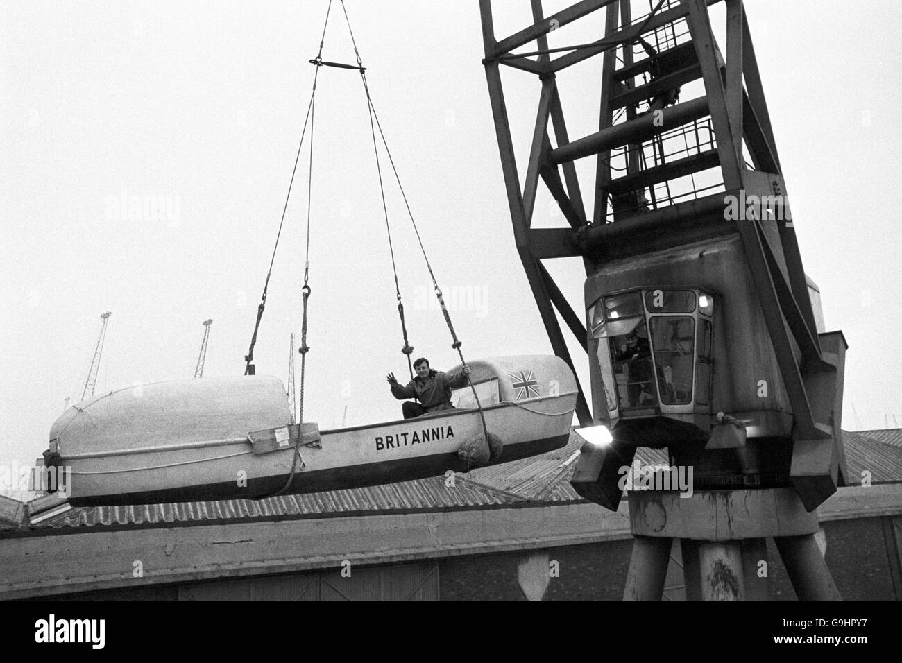 1,500 rowing boat which he hopes to row across the Atlantic and be the first man to do so single handed. It was being hoisted onto the Aragon at King George V Dock in London. The boat designed by Uffa Fox, is being shipped to Las Palmas, Canary Islands from where the attempt will be made to row the 3,500 miles to Florida, USA. Stock Photo
