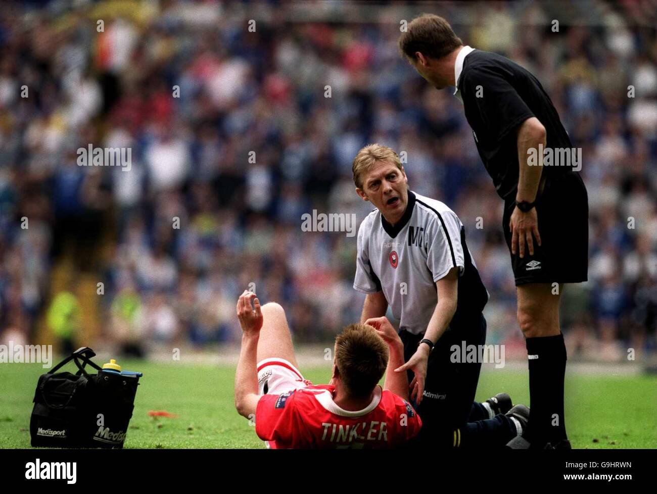 Barnsley's Erik Tinkler receives treatment from the physio as referee Mark Halsey enquires about the players condition Stock Photo