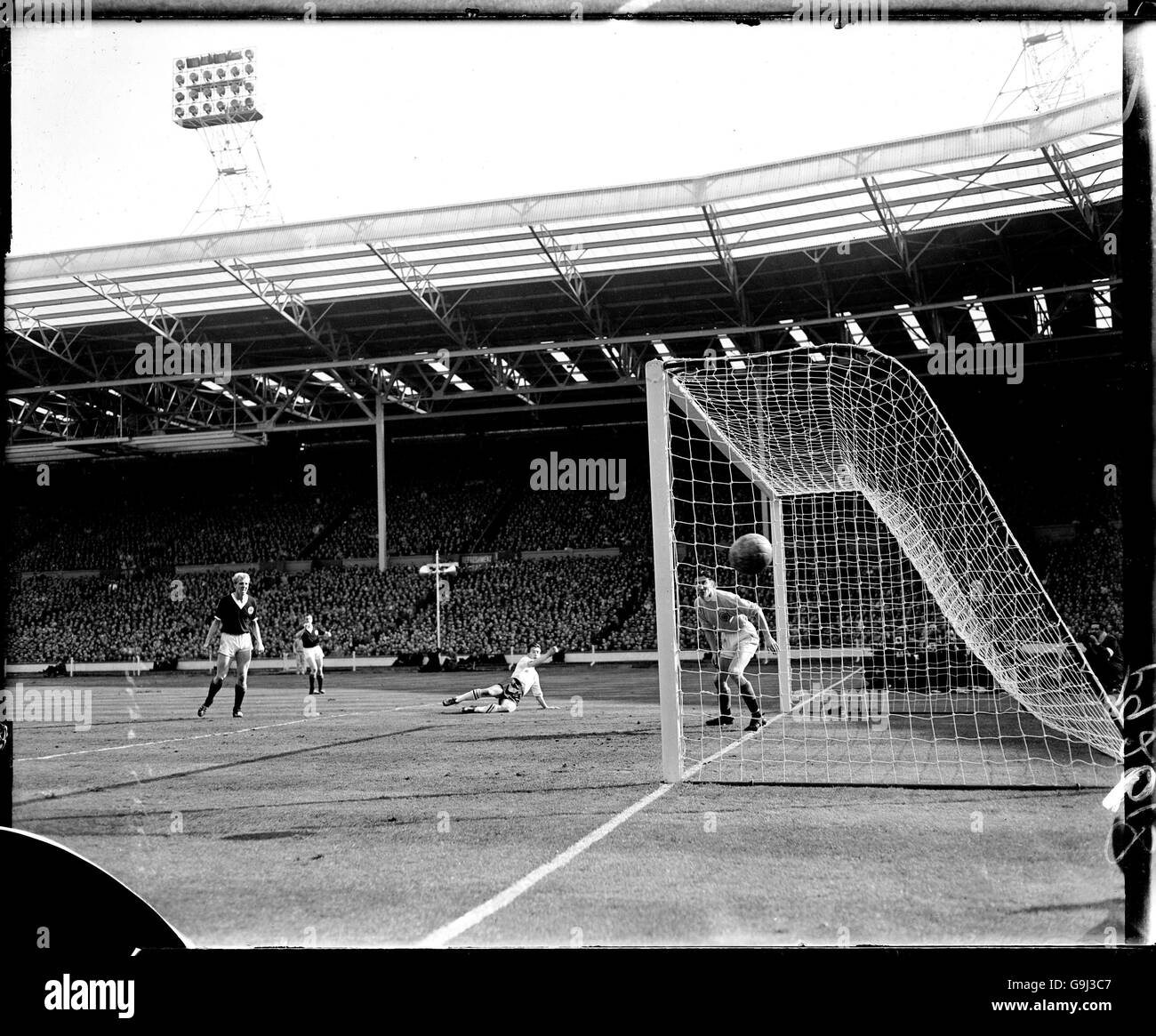 (R-L) Scotland goalkeeper Bill Brown watches as a header from England's Bryan Douglas drifts wide Stock Photo
