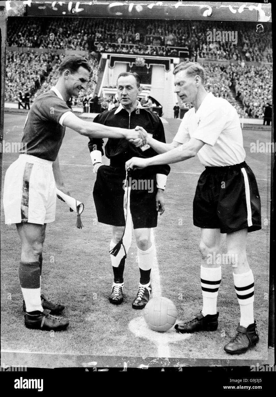 Nottingham Forest captain Jack Burkitt (l) shakes hands with Luton Town  captain Syd Owen (r), watched by referee J Clough (c Stock Photo - Alamy