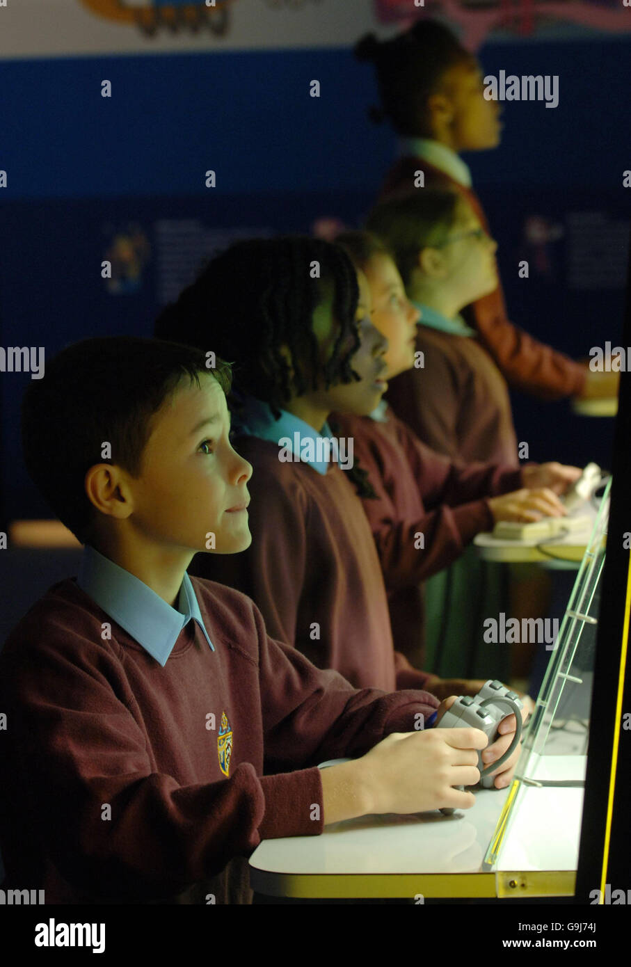 Children visiting the 'Game On' exhibition at the Science Museum in London play computer games which form part of an exhibition of arcade and computer games dating from 1962 to the present day. Stock Photo