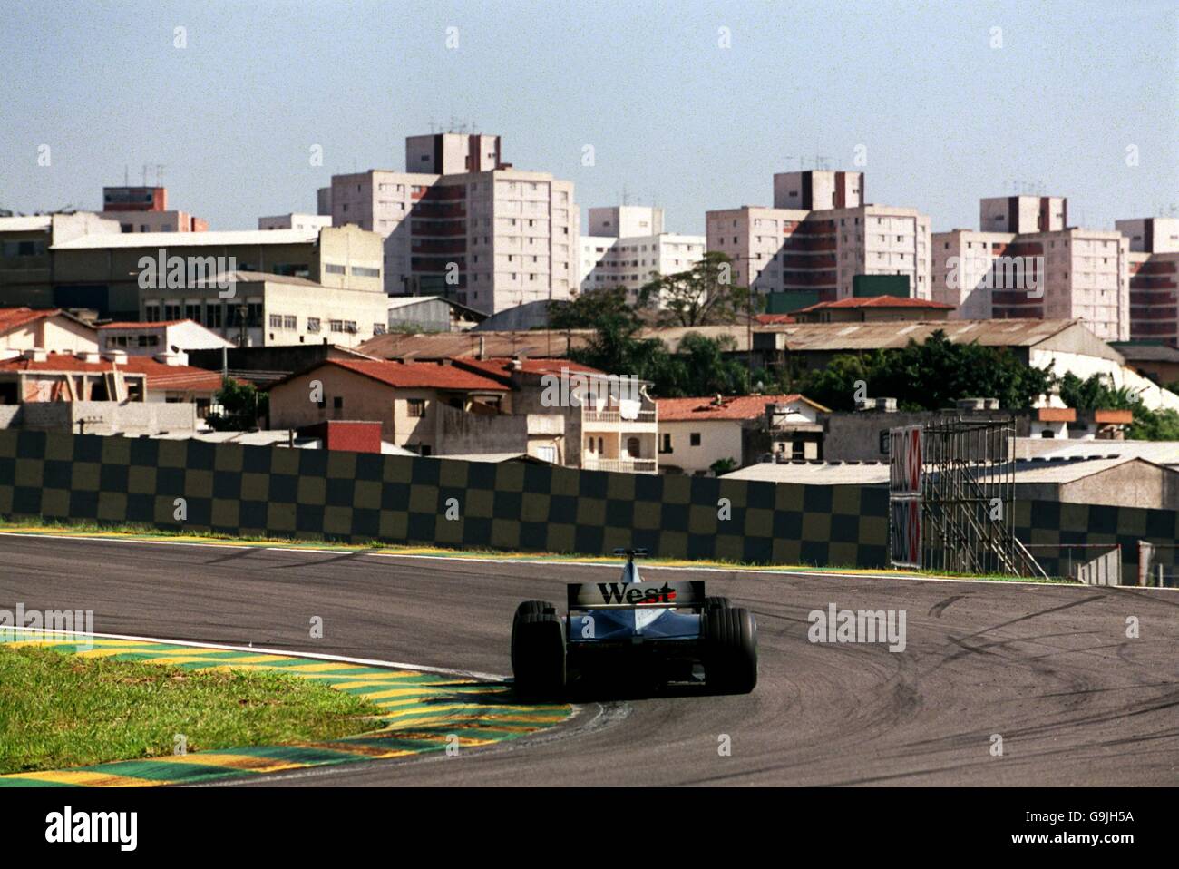 Formula One Motor Racing - Brazilian Grand Prix - Qualifying. A view over Sao Paulo is visible as McLaren's David Coulthard takes a corner Stock Photo