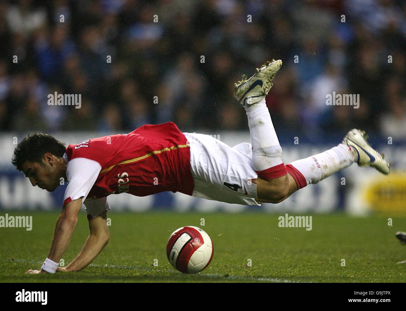 Arsenal's Francesc Fabregas is brought down by Reading goalkeeper Marcus Hahnemann (out of picture) Stock Photo
