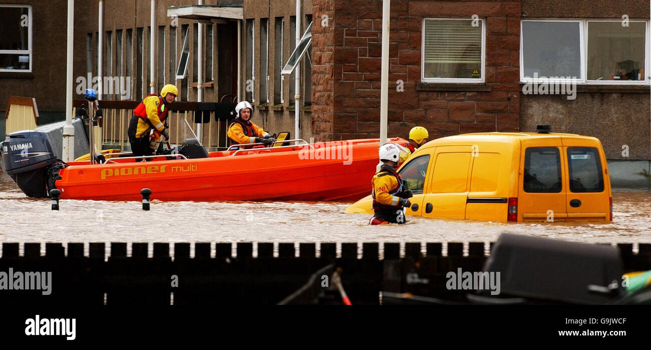 Heavy rain causes flooding. A rescue team moves locals to dry land following flooding in Dingwall near Inverness. Stock Photo