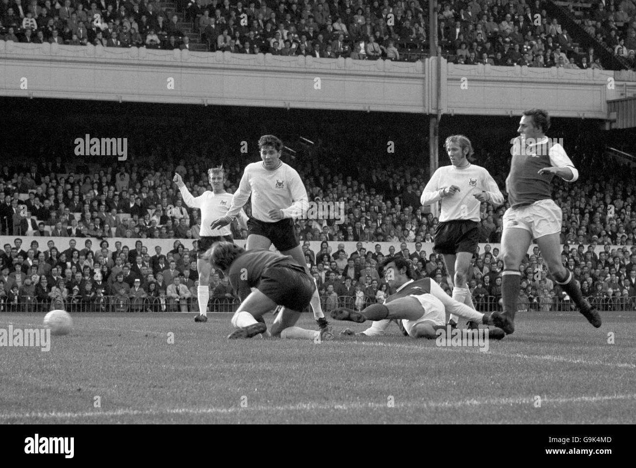 Arsenal's Ray Kennedy (third r) sweeps the ball past Nottingham Forest goalkeeper Jim Barron (second l) to score his team's second goal, watched by teammate John Radford (r) and Forest's John Winfield (l), Peter Hindley (third l) and Liam O'Kane (second r) Stock Photo