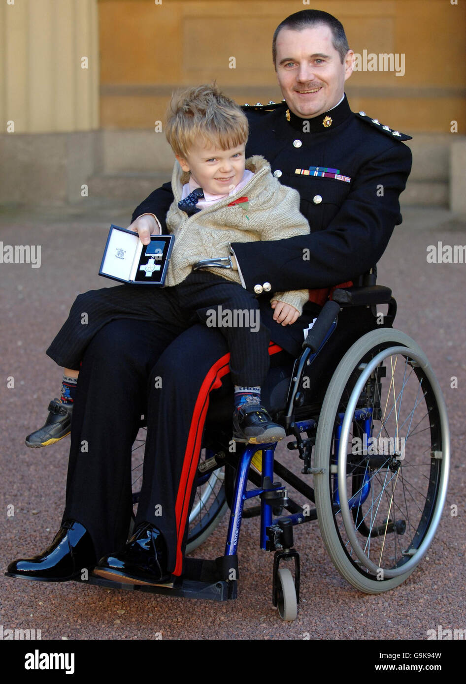 Disabled Iraq War bomb victim, Captain Peter Norton of the Royal Logistics Corp with his George Cross after collecting it from the Princess Royal, who was standing in for Queen Elizabeth II, during an Investiture ceremony at Buckingham Palace, London today. He is accompanied by his son Tom, 3. Press Association Photo. Picture date Thursday November 2 2006. ROTA Photo credit should read Fiona Hanson/PA Stock Photo