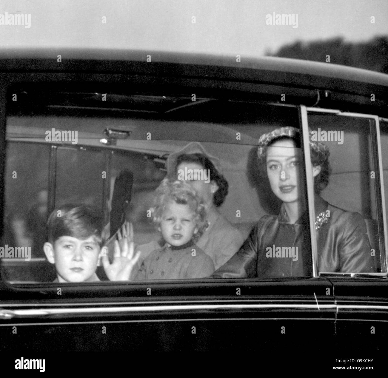 Prince Charles and Princess Anne rise their hands in salute to the crowd waiting to welcome them as they drove with their mother, the Queen, and aunt, Princess Margaret into Buckingham Palace on the Royal family's return from holiday at Balmoral. Stock Photo