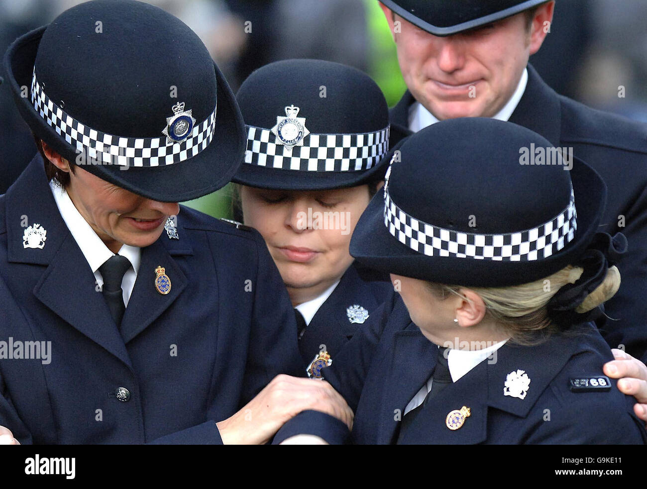 WPC Teresa Milburn (second left) is consoled by colleagues during a memorial service for fellow officer Sharon Beshenivsky in Bradford. Stock Photo