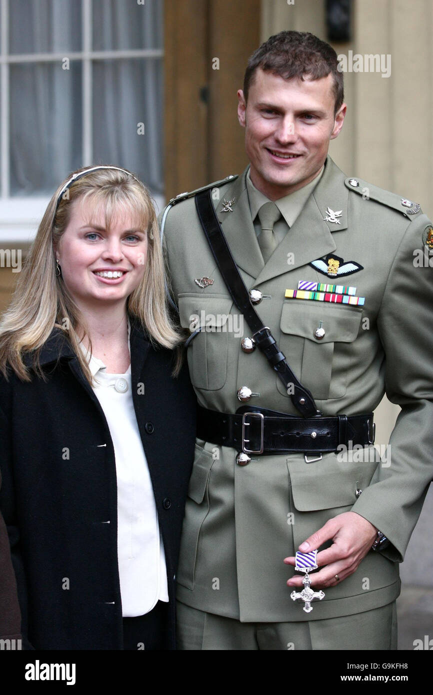 Major Scott Watkins of the Australian Army Aviation corps, stands with his wife Karen as he proudly displays his Distinguished Flying Cross at Buckingham Palace, in central London. Stock Photo